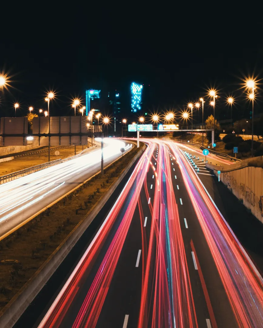 La autovía A-1 de noche a su paso por San Sebastián de los Reyes, con farolas de sodio y estelas de luz del tráfico